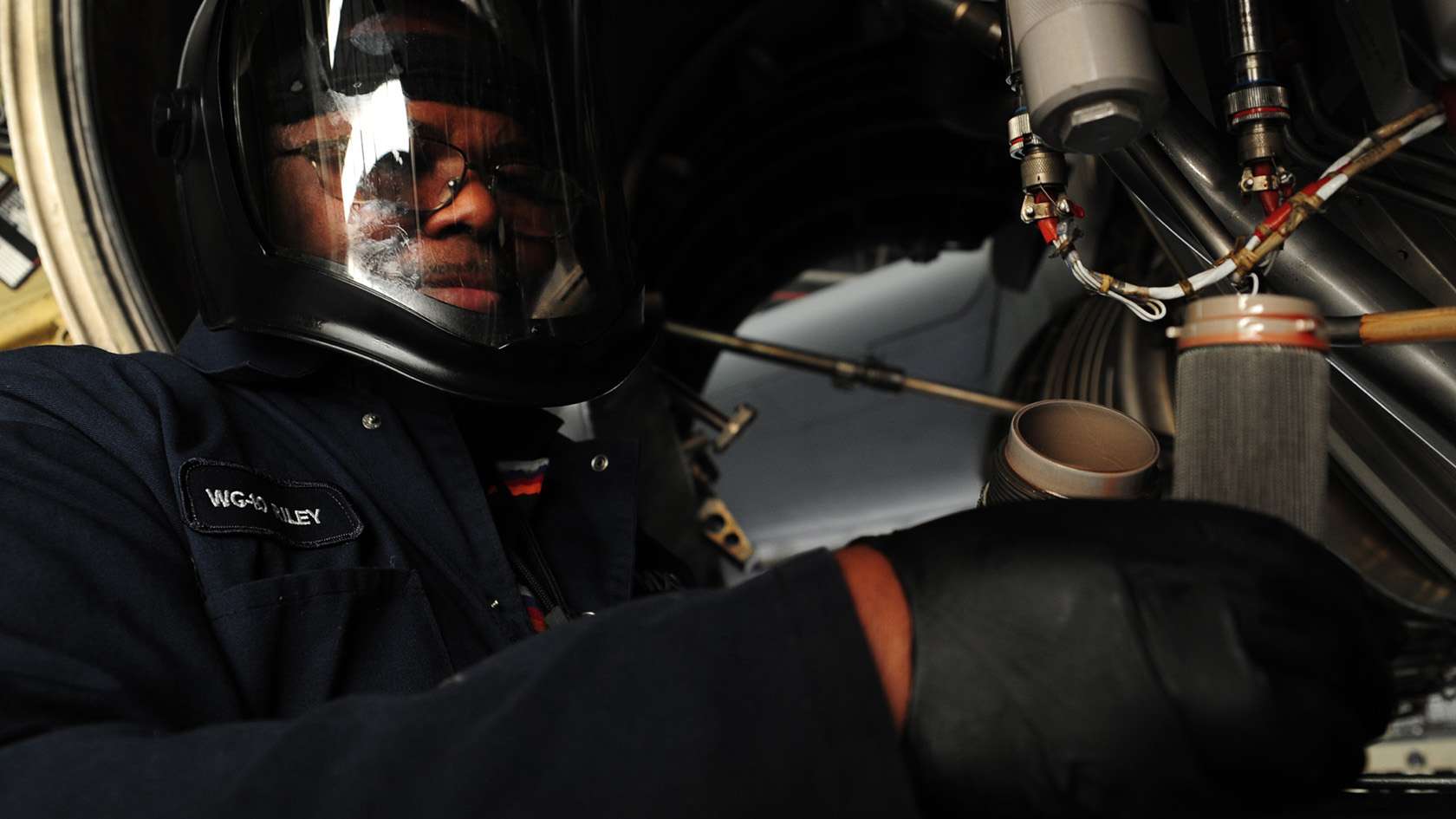 airman wearing faceshield performing maintenance