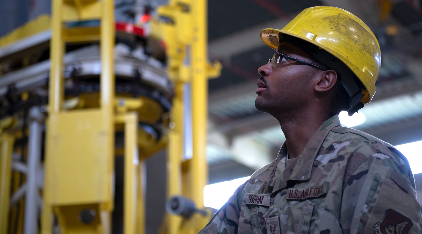 airman wearing yellow hard hat in water plant