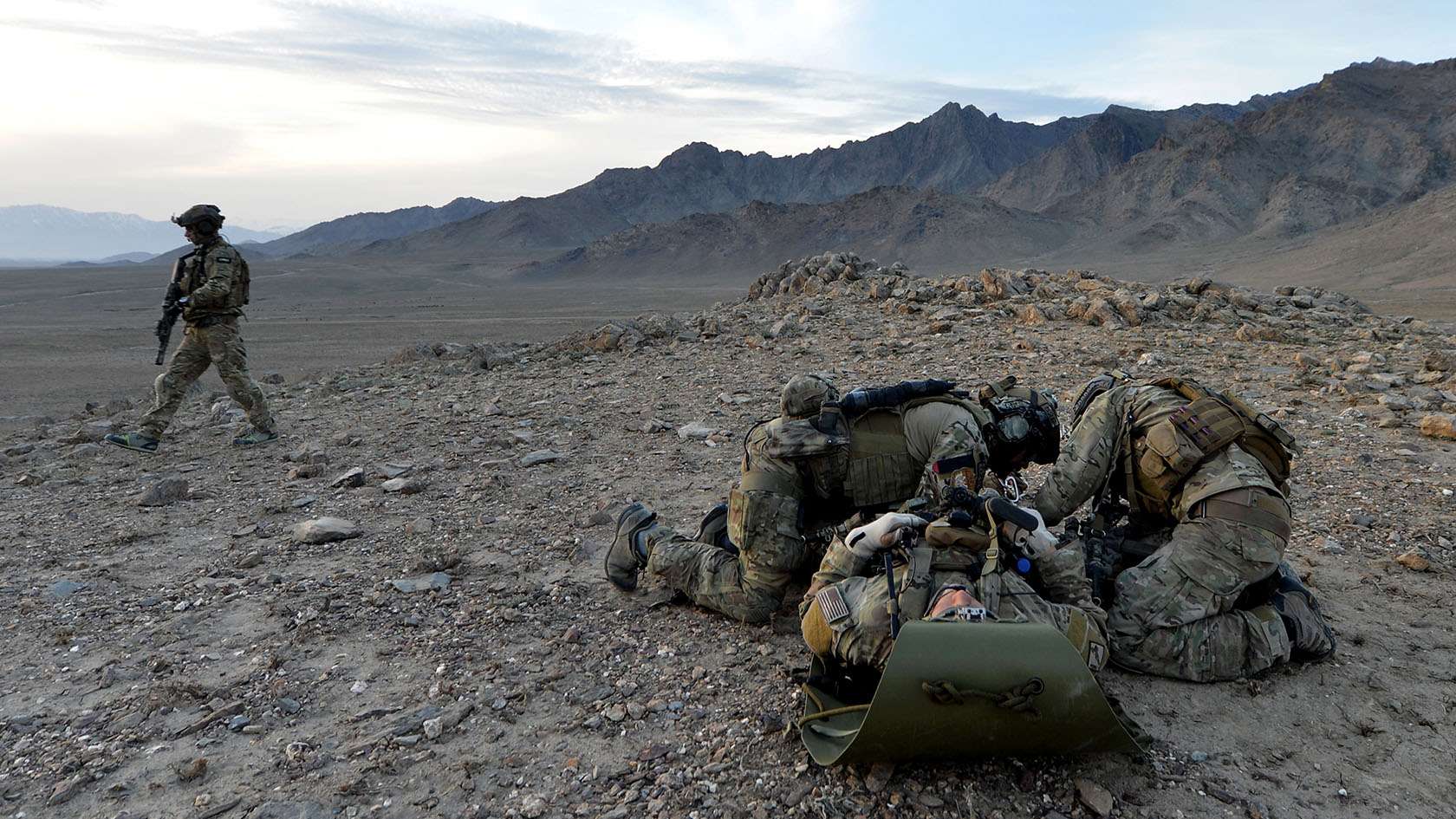 Two Combat Rescue Officers providing medical attention on a mountainside
