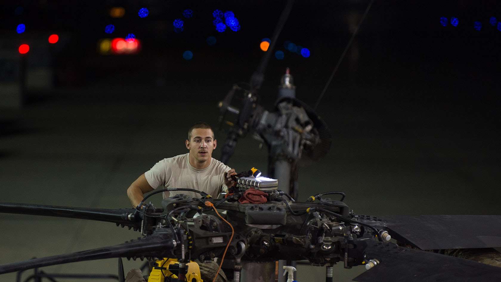 airman performing helicopter maintenance