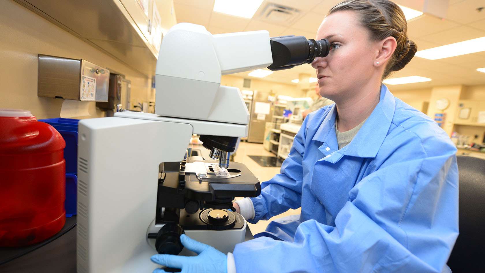 airman looking through a microscope