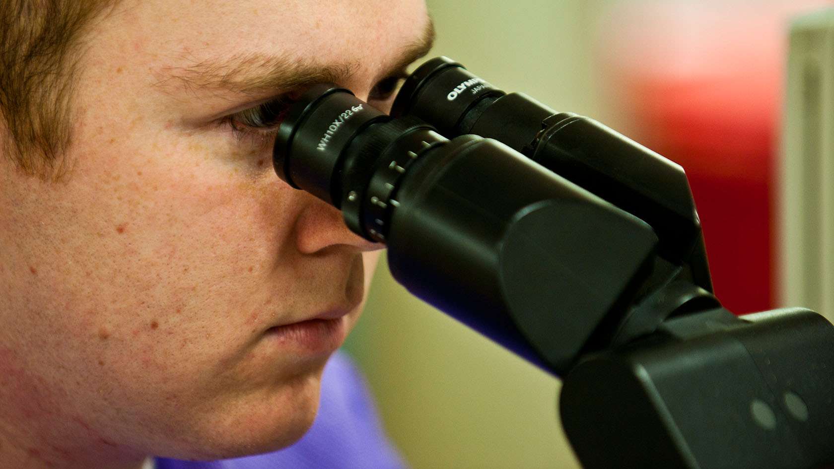 airman looking through a microscope