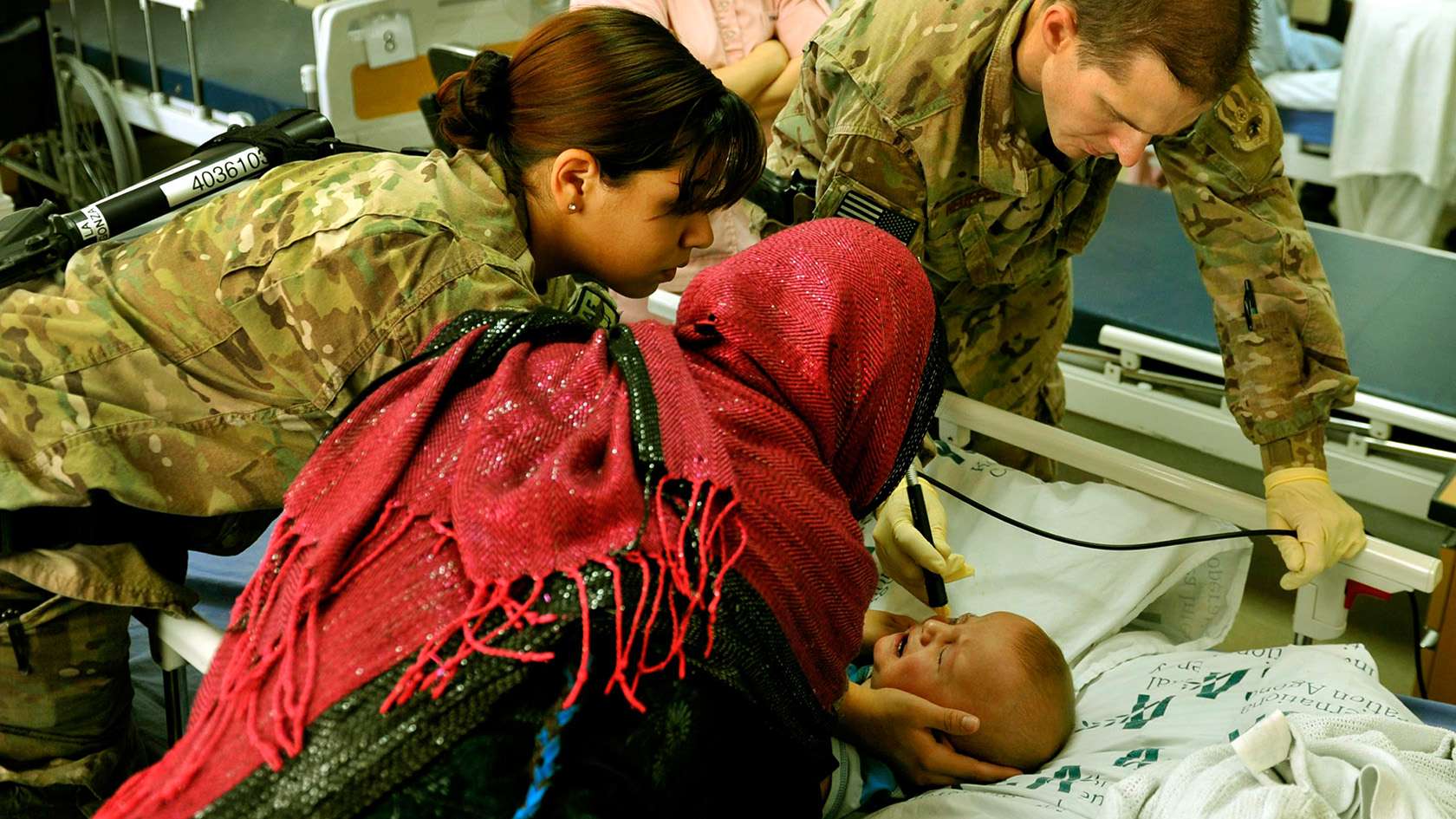 Air Force ophthalmologists attending to a baby