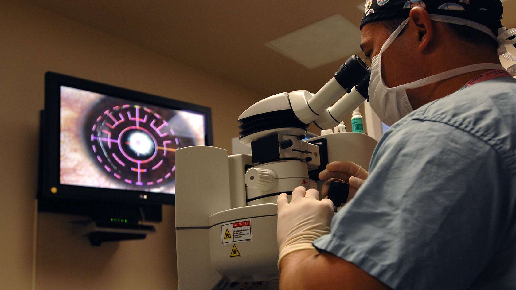 Ophthalmologist looking into eye using device