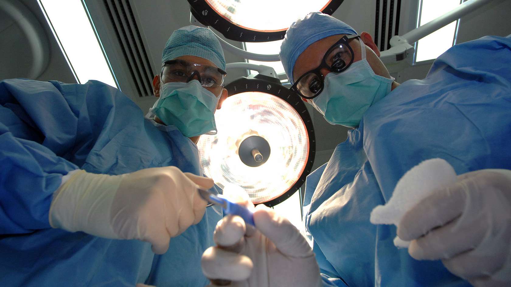 patient's pov: two orthorpedic surgeons operating 