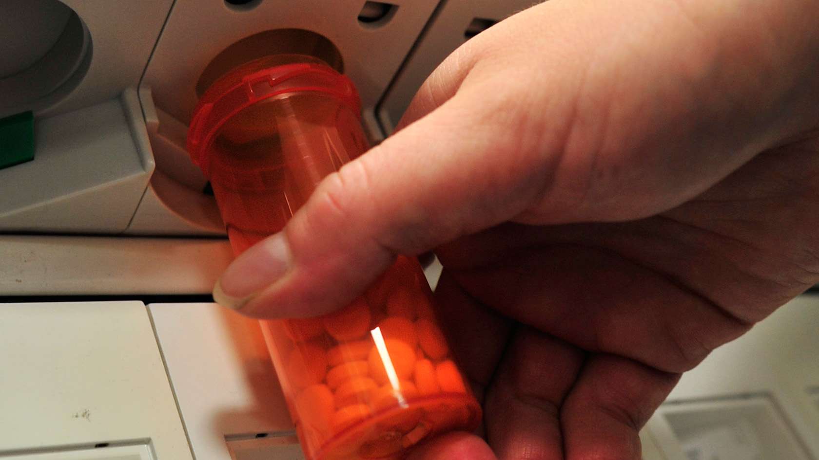 pharmacist refilling medicine vial