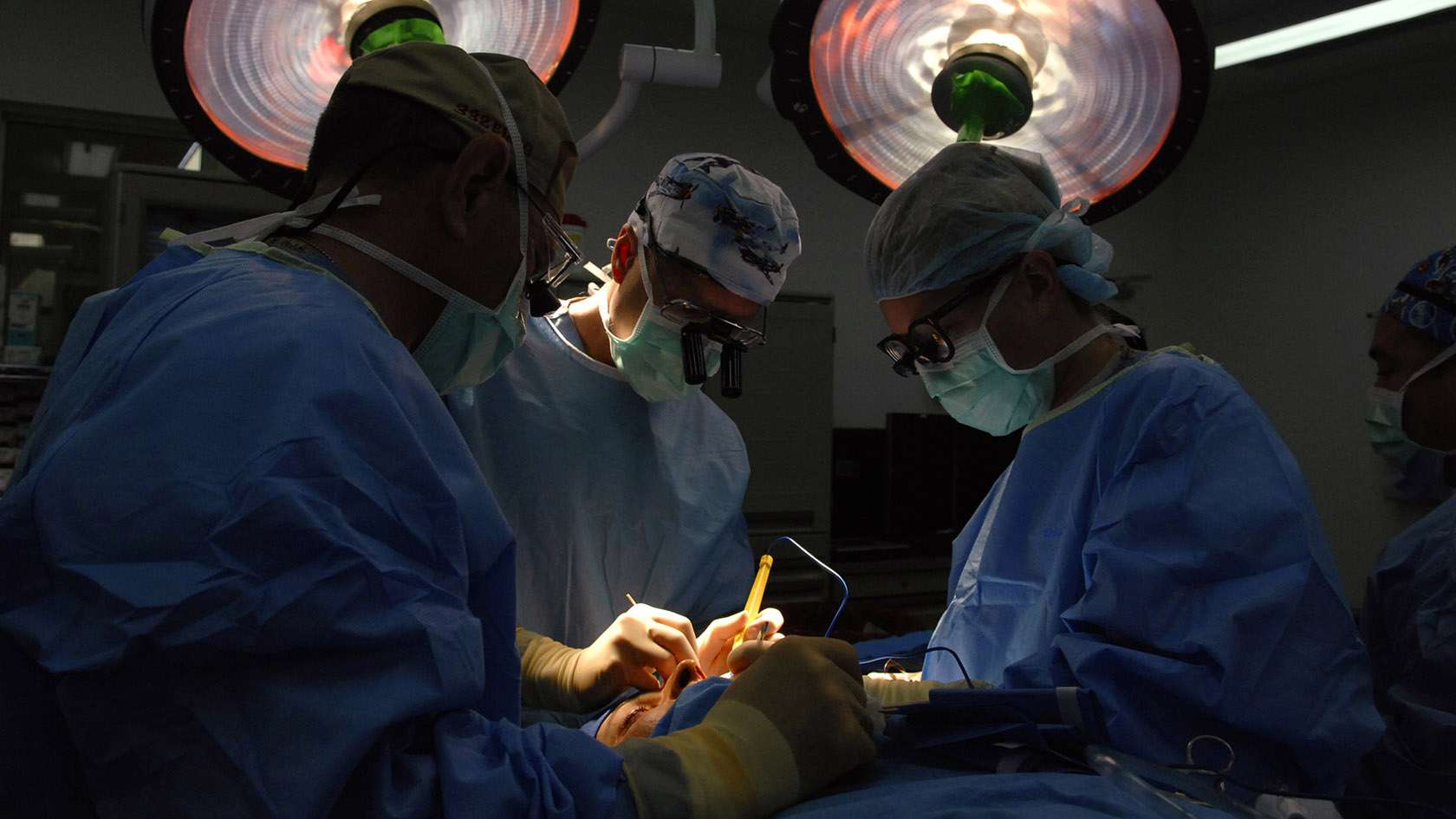 surgical team of three working together on a patient