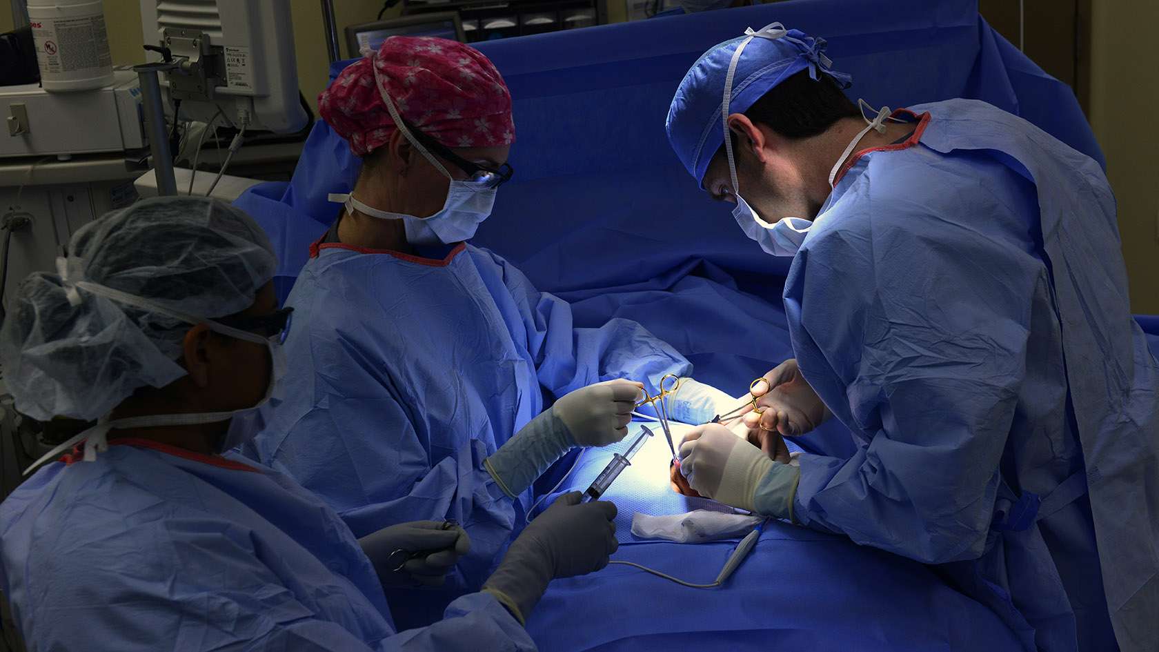 surgical team of three collaborating in the operating room 