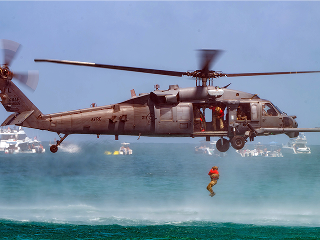 helicopter over the sea with a soldier descending