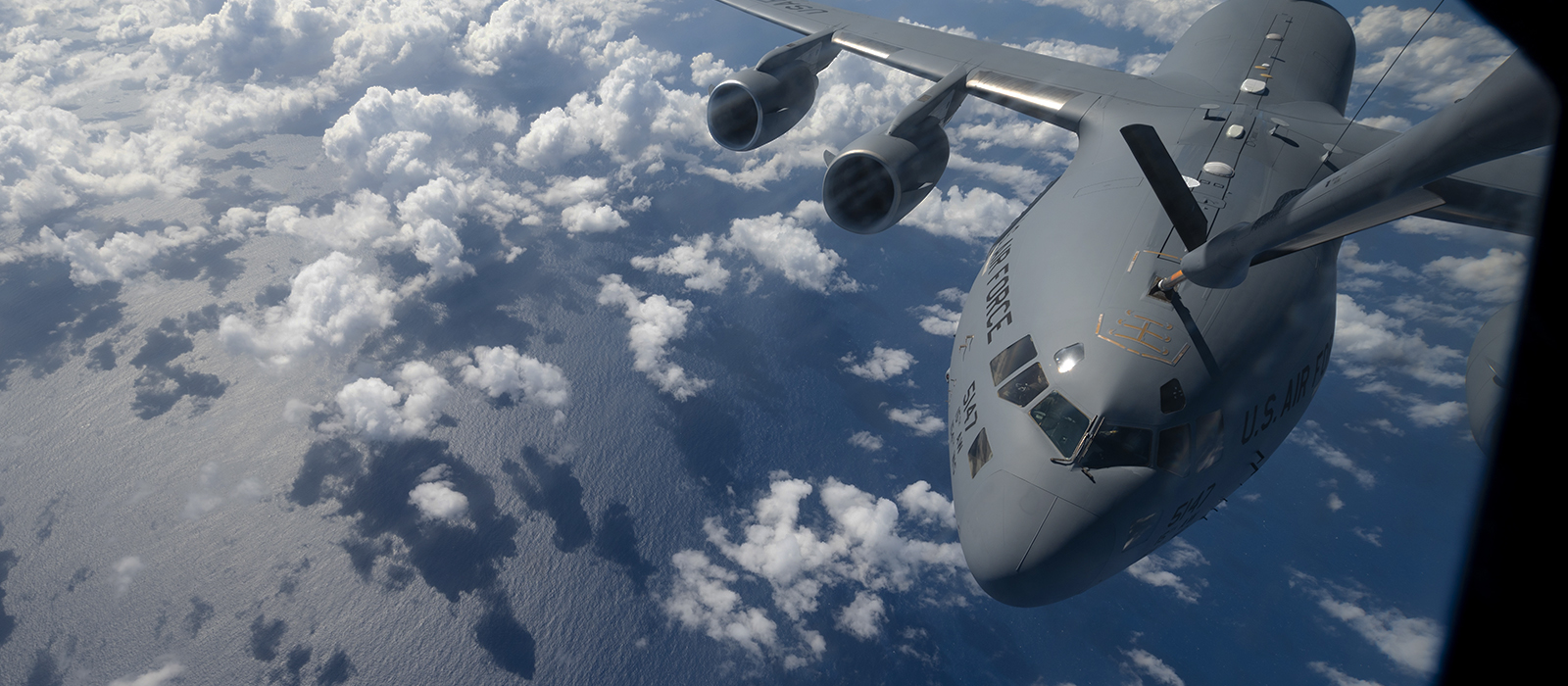 air force plane flying over the clouds