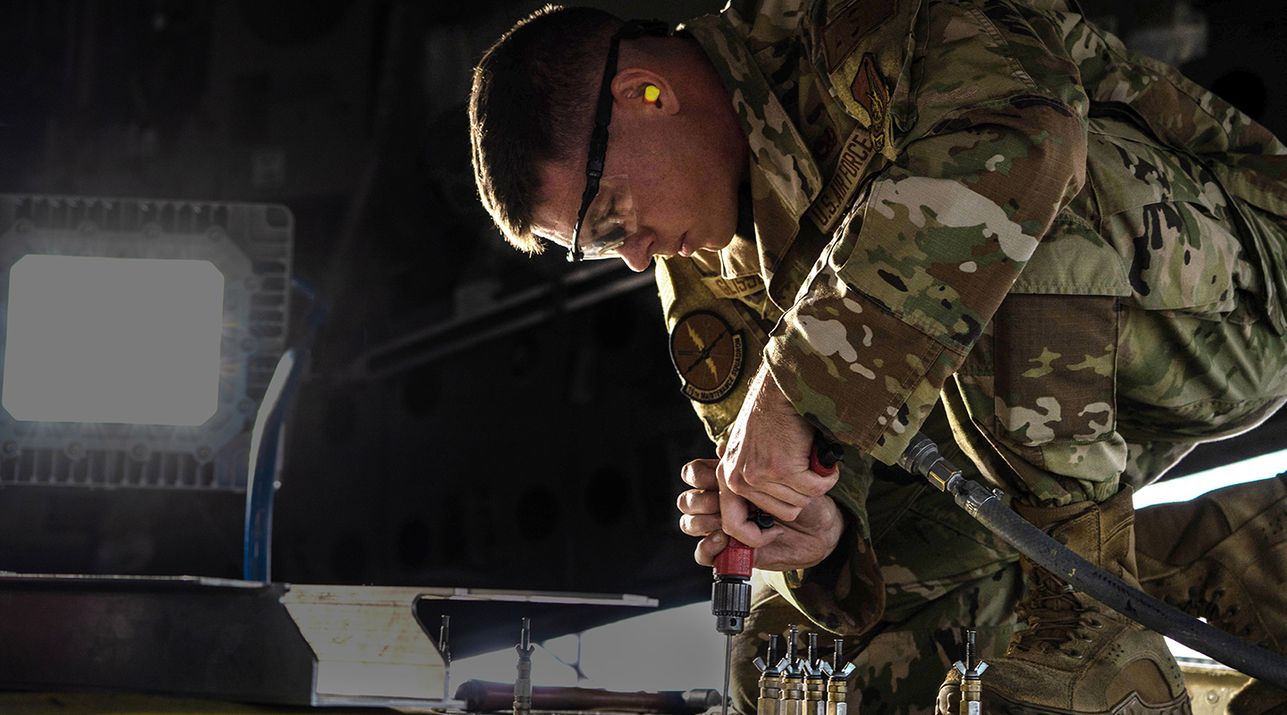 airman installing replacement aircraft parts