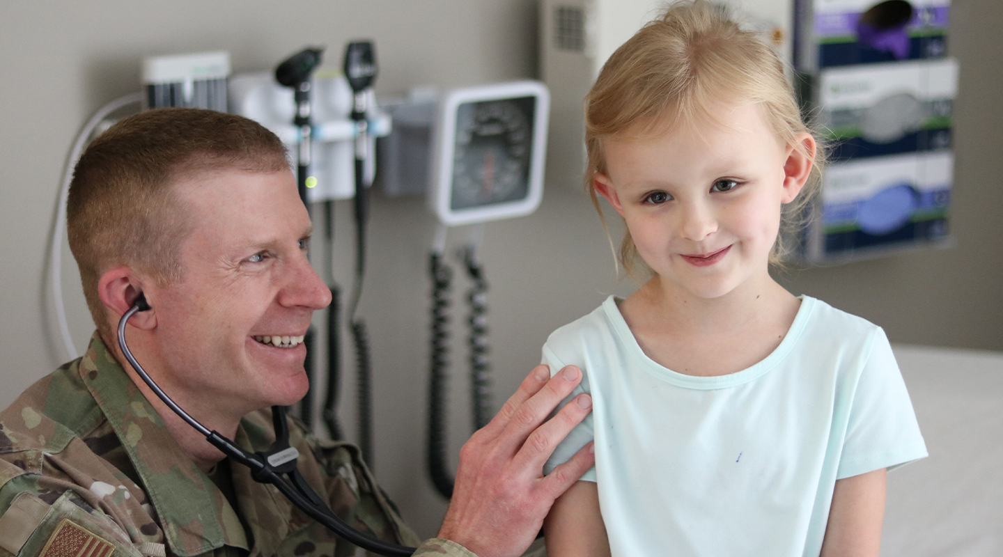 family nurse practitioner engaging with a little girl who is his patient