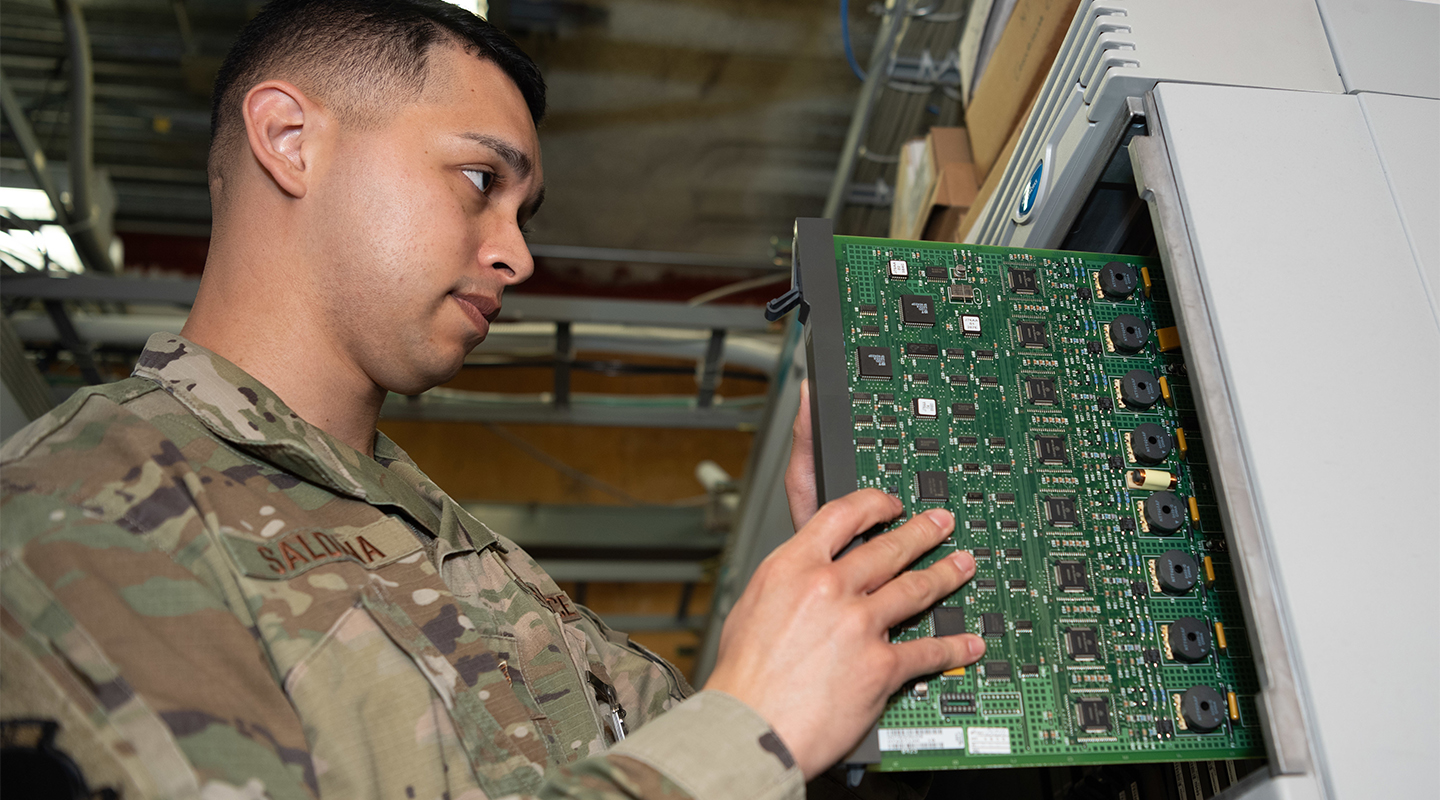Health Services Management specialist working on a circuit board