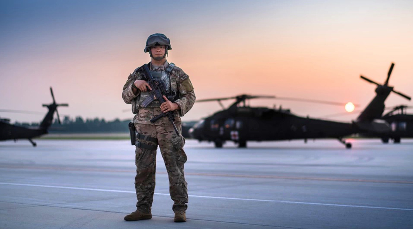 airman standing with a gun looking at the camera